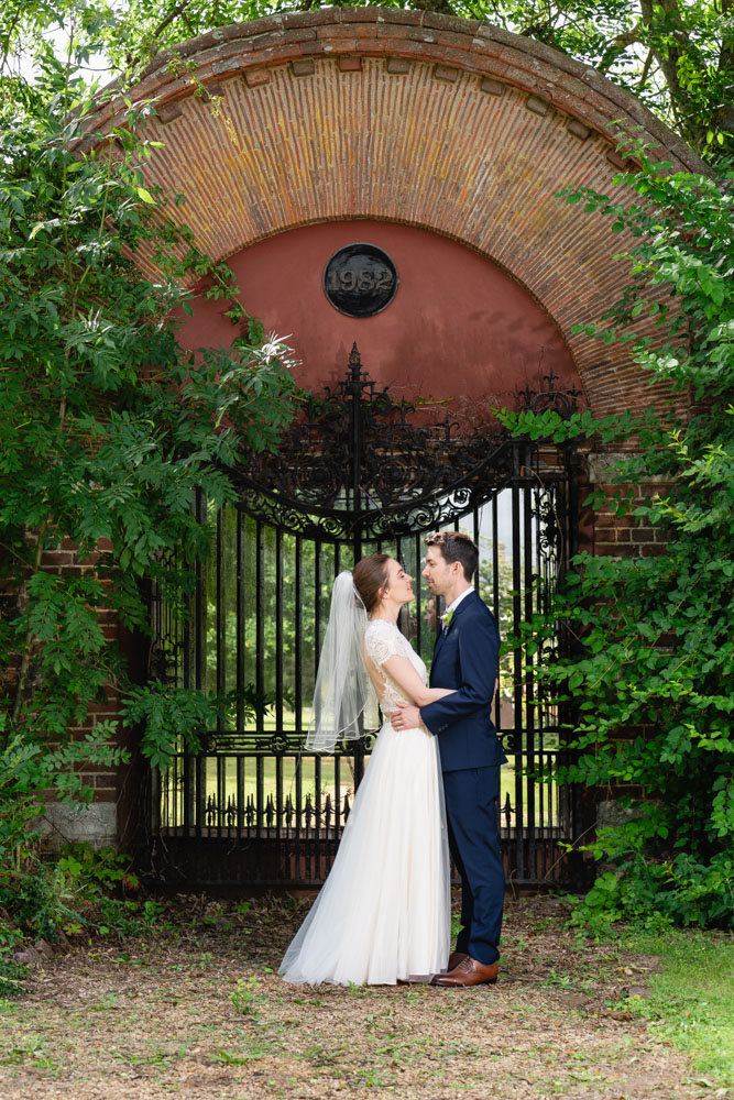 Wedding photography Oxfordshire. Bride and groom at mirrored gate in gardens of Milton Hill House.