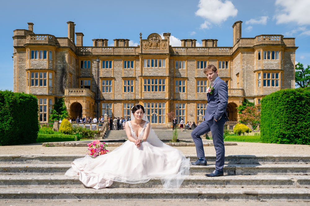 Wedding photography Oxfordshire. Bride and groom on steps of Eynsham Hall
