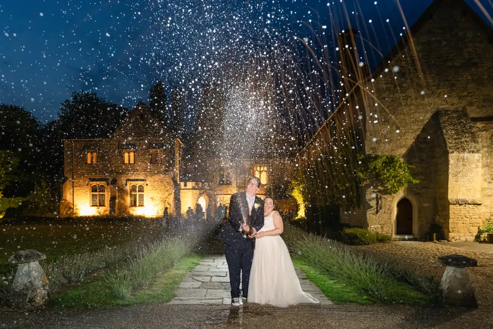 Buckinghamshire wedding photography of Bride and groom doing champagne spray at Notley Abbey wedding.