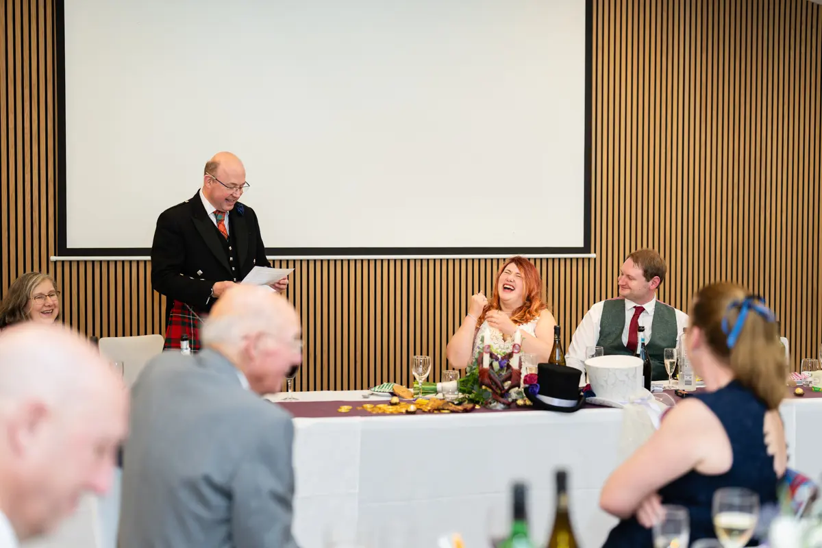 Bride and groom laughing during speeches at their Garden House Venue wedding in Steventon, Oxfordshire.