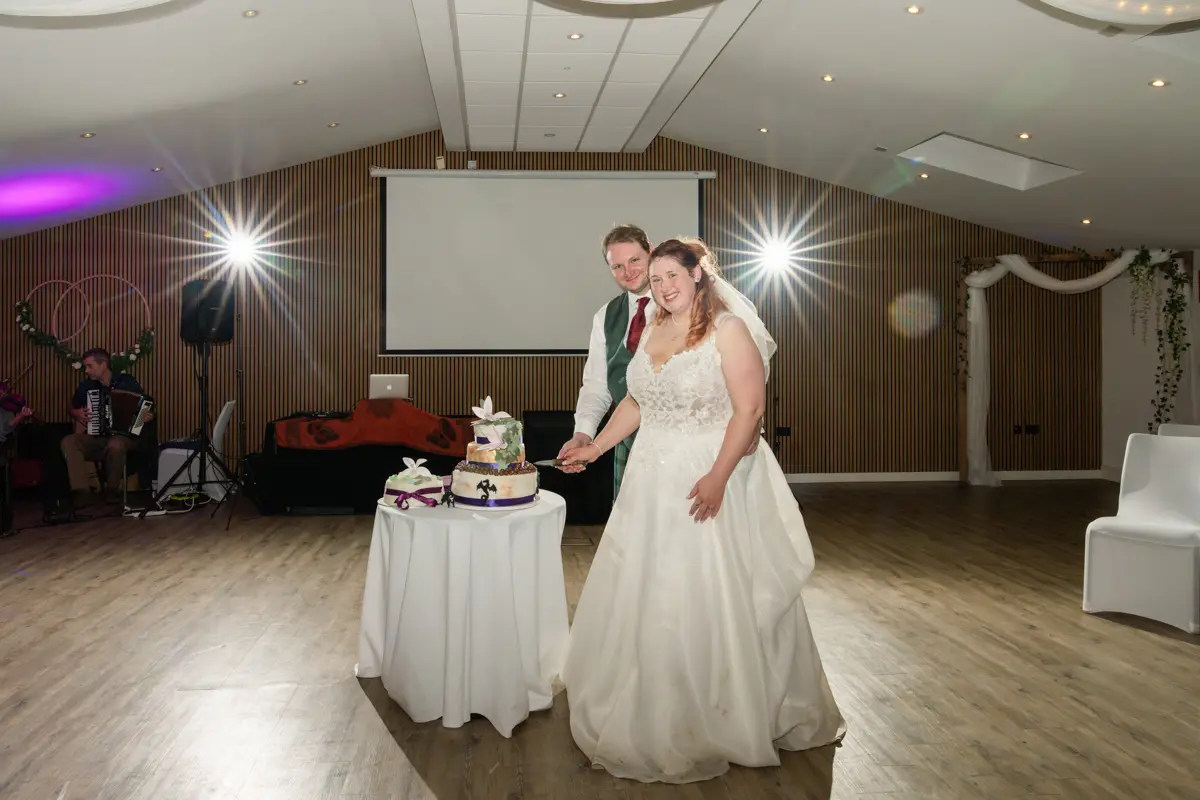 Bride and groom cutting cake at their Garden House Venue wedding in Steventon, Oxfordshire.