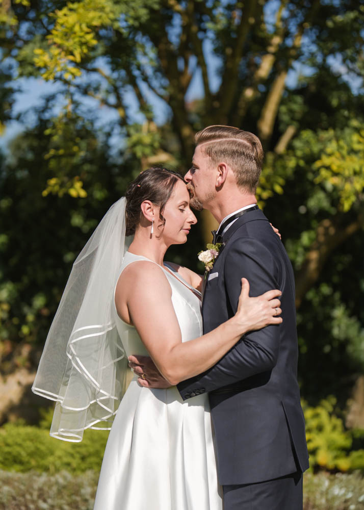 Le Manoir wedding photographer with bride and groom in embrace in gardens of Le Manoir aux Quat'Saisons.