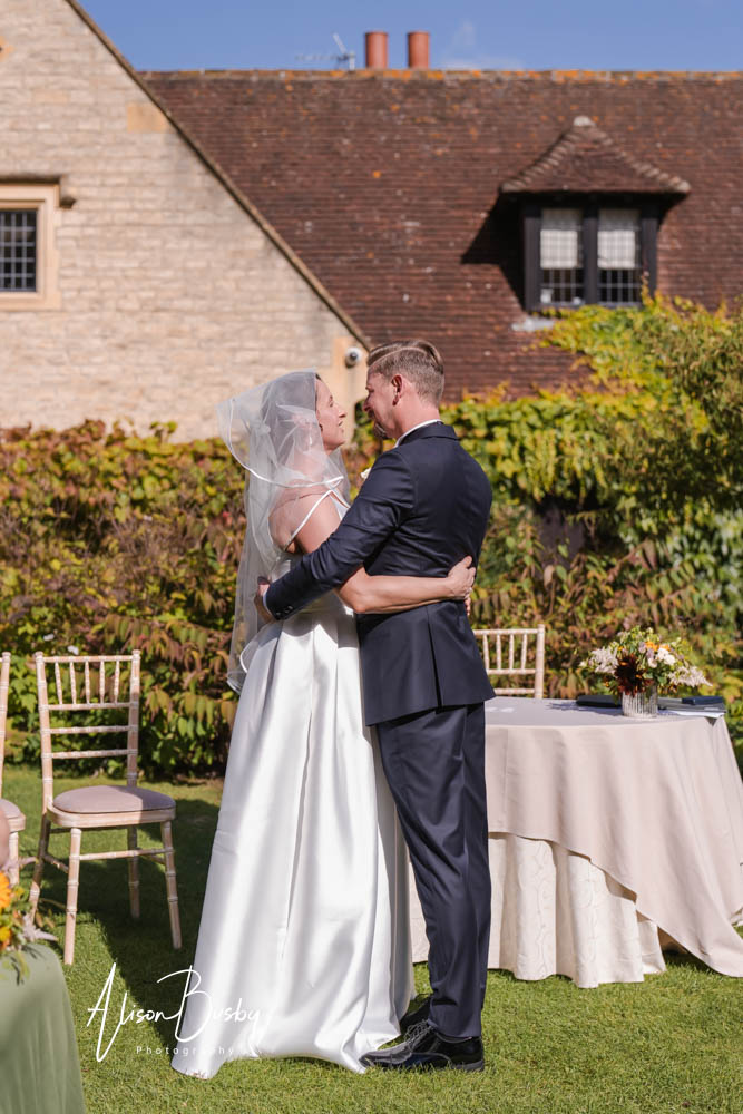 Bride and groom before first kiss during outdoor wedding ceremony at Le Manoir aux Quat'Saisons. Photo by Alison Busby