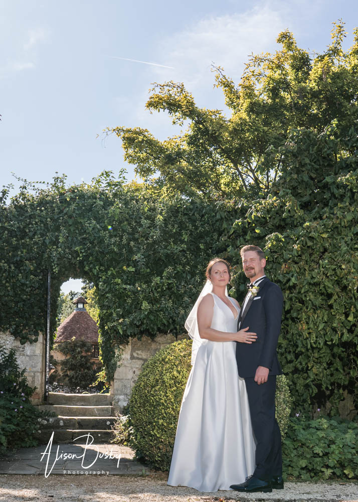 Bride and groom in vegetable garden at Le Manoir aux Quat'Saisons wedding by photographer Alison Busby