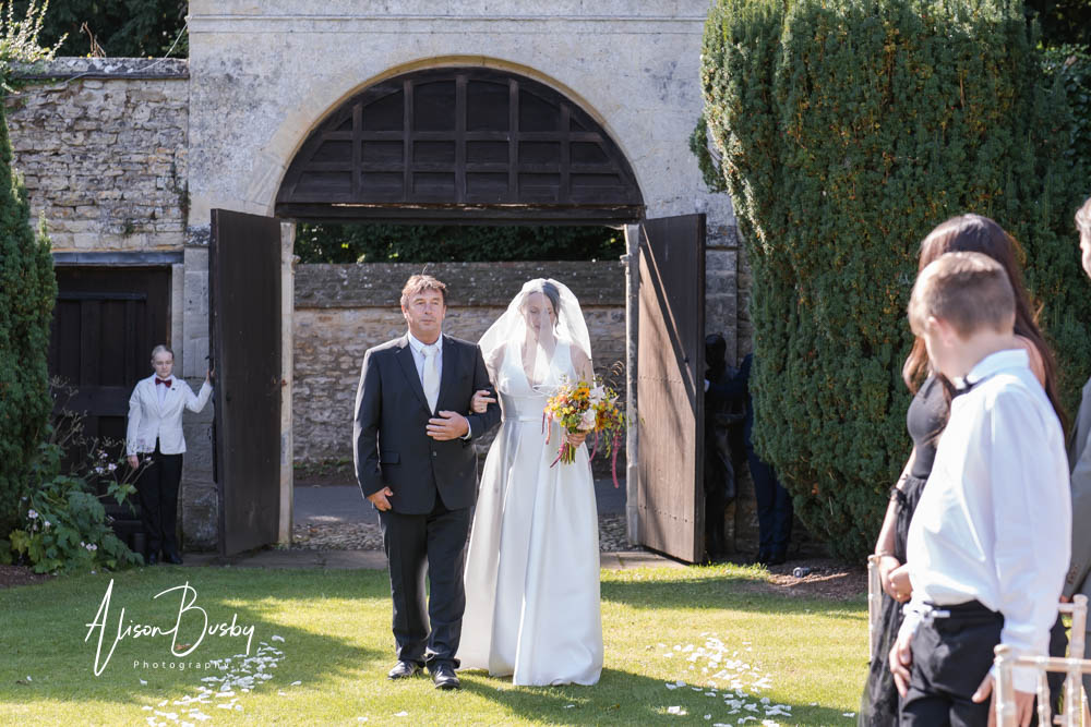 Bride arrives for Outdoor wedding ceremony at Le Manoir aux Quat'Saisons. Photo by Alison Busby
