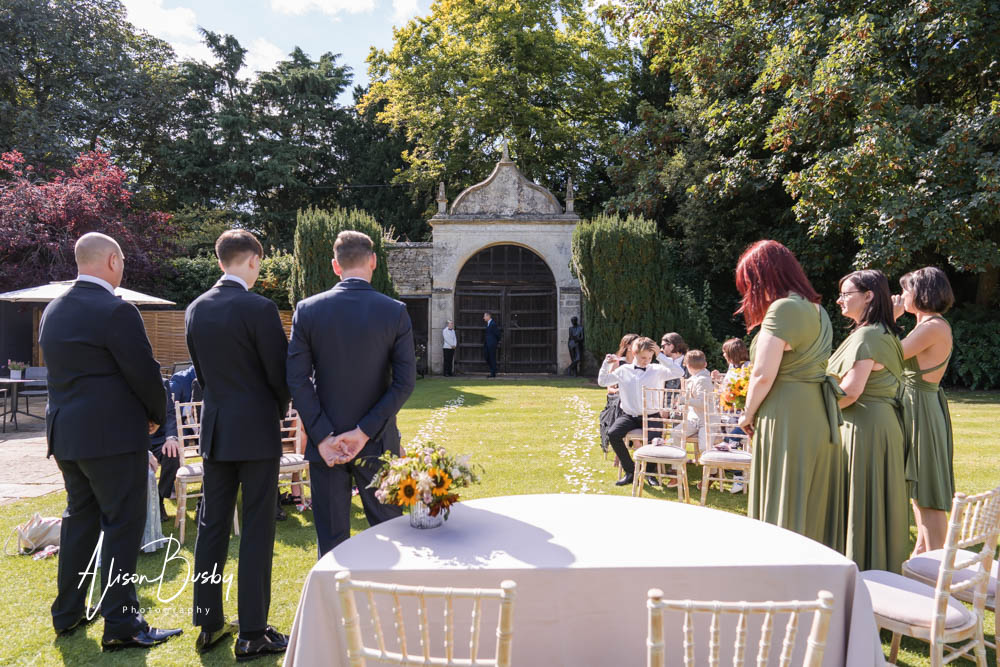 Natural wedding photography at Le Manoir aux Quat'Saisons in Oxfordshire. Wedding party and guest await the arrival of the bride.