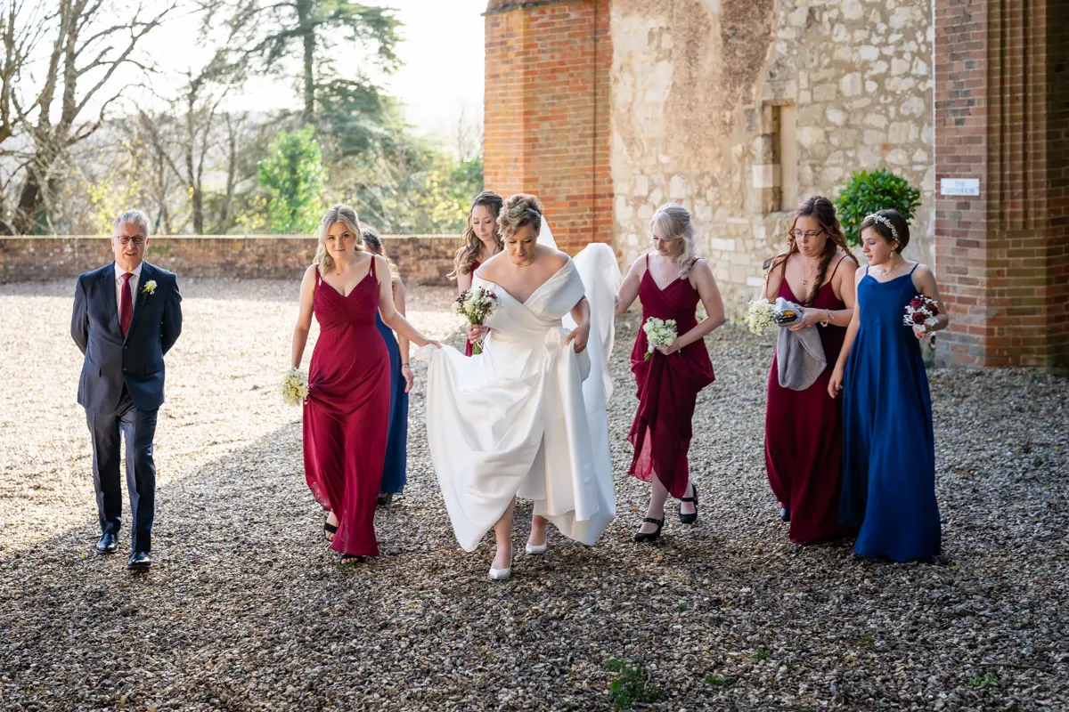 Bridal party leaving gatehouse for ceremony at Farnham Castle wedding.