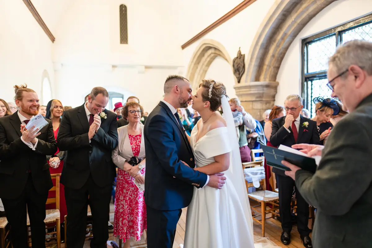 Bride and groom first kiss at Farnham Castle wedding.