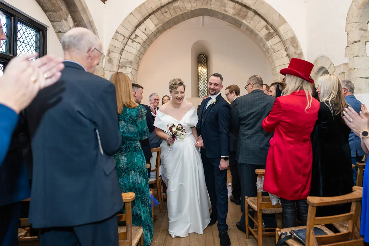 Bride and groom leaving ceremony at Farnham Castle wedding.