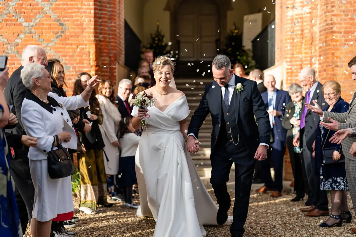 Bride and groom in confetti tunnel at Farnham Castle wedding.