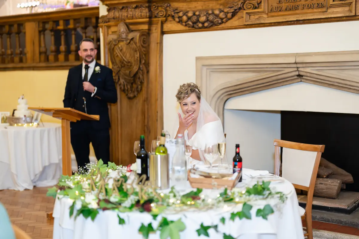Bride laughing during groom's speech at Farnham Castle wedding.