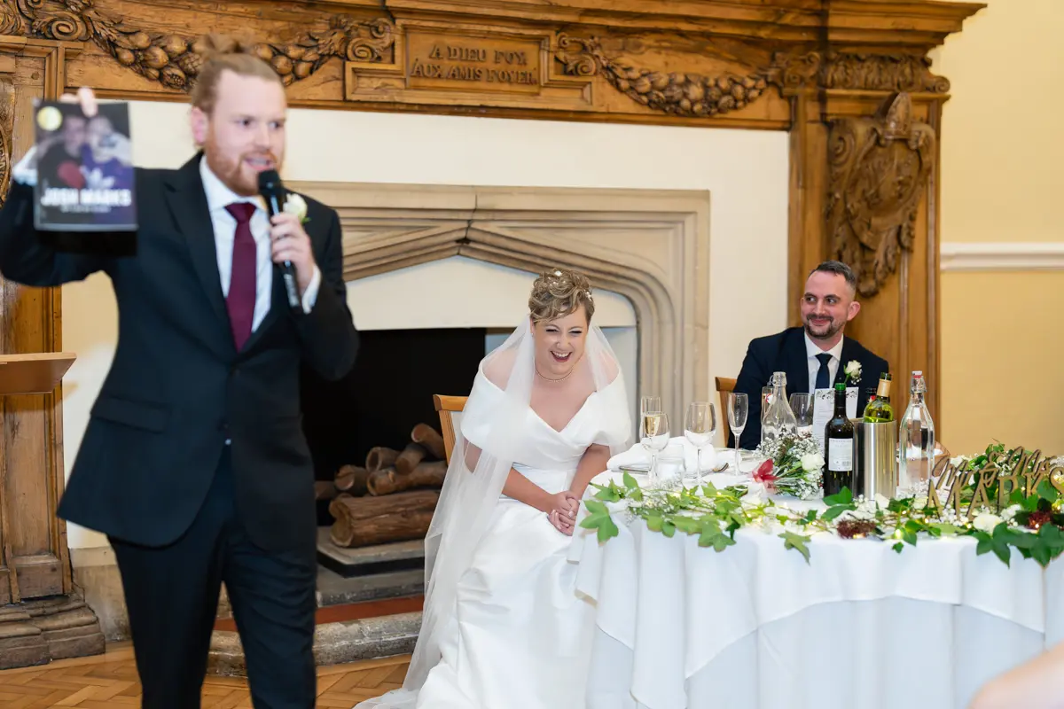 Bride laughing during speeches at Farnham Castle wedding.