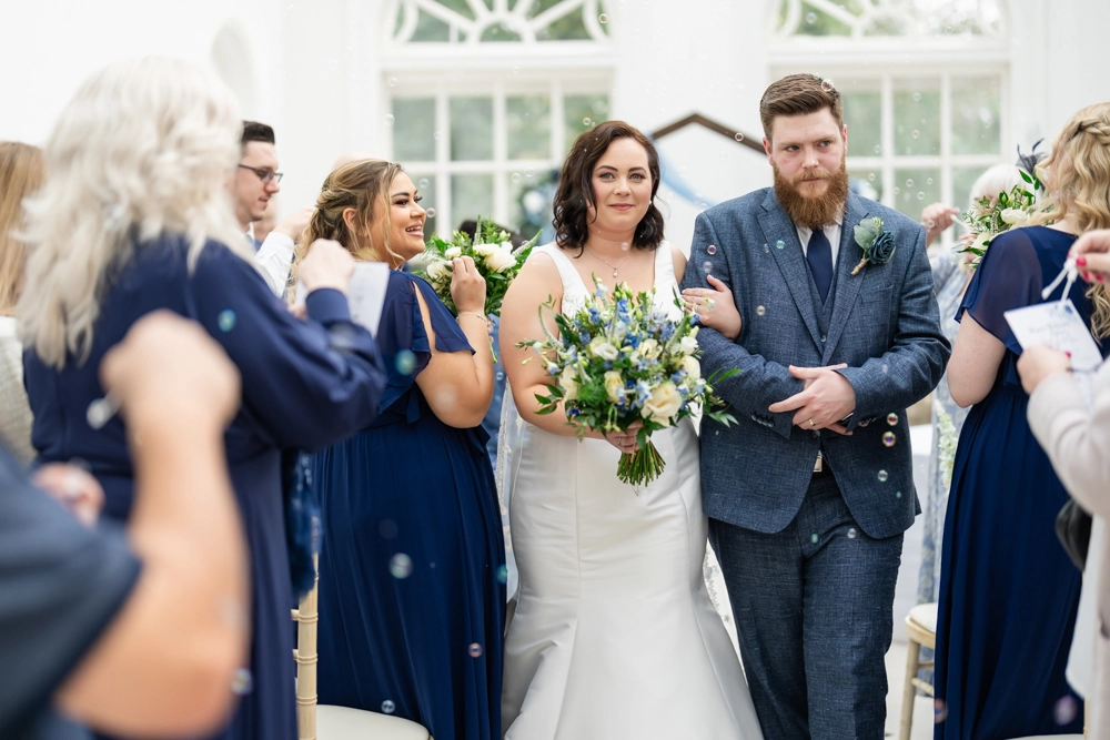 Bride and groom leaving ceremony in conservatory. Hunton Park wedding photographer.