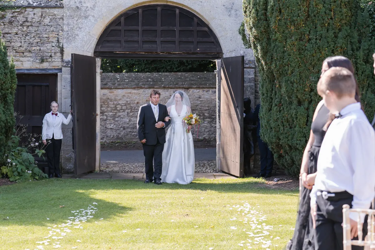 Bride arrives for outdoor ceremony at Le Manoir wedding.