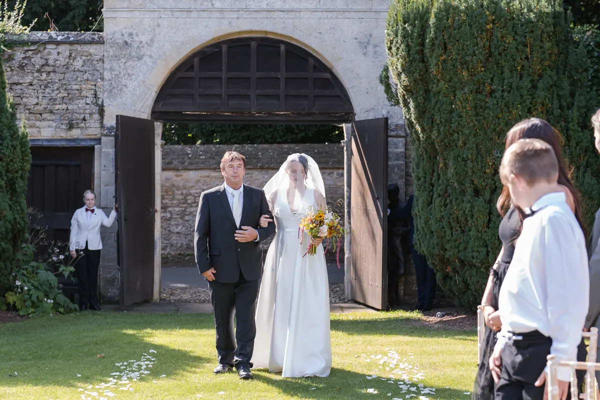 Bride arrives for outdoor ceremony at Le Manoir wedding.