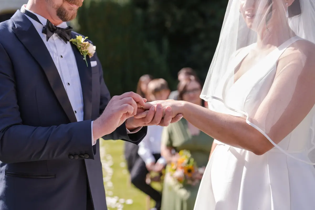 Bride and groom exchange rings at their Le Manoir wedding in September. la belle epoque outdoor wedding ceremony.