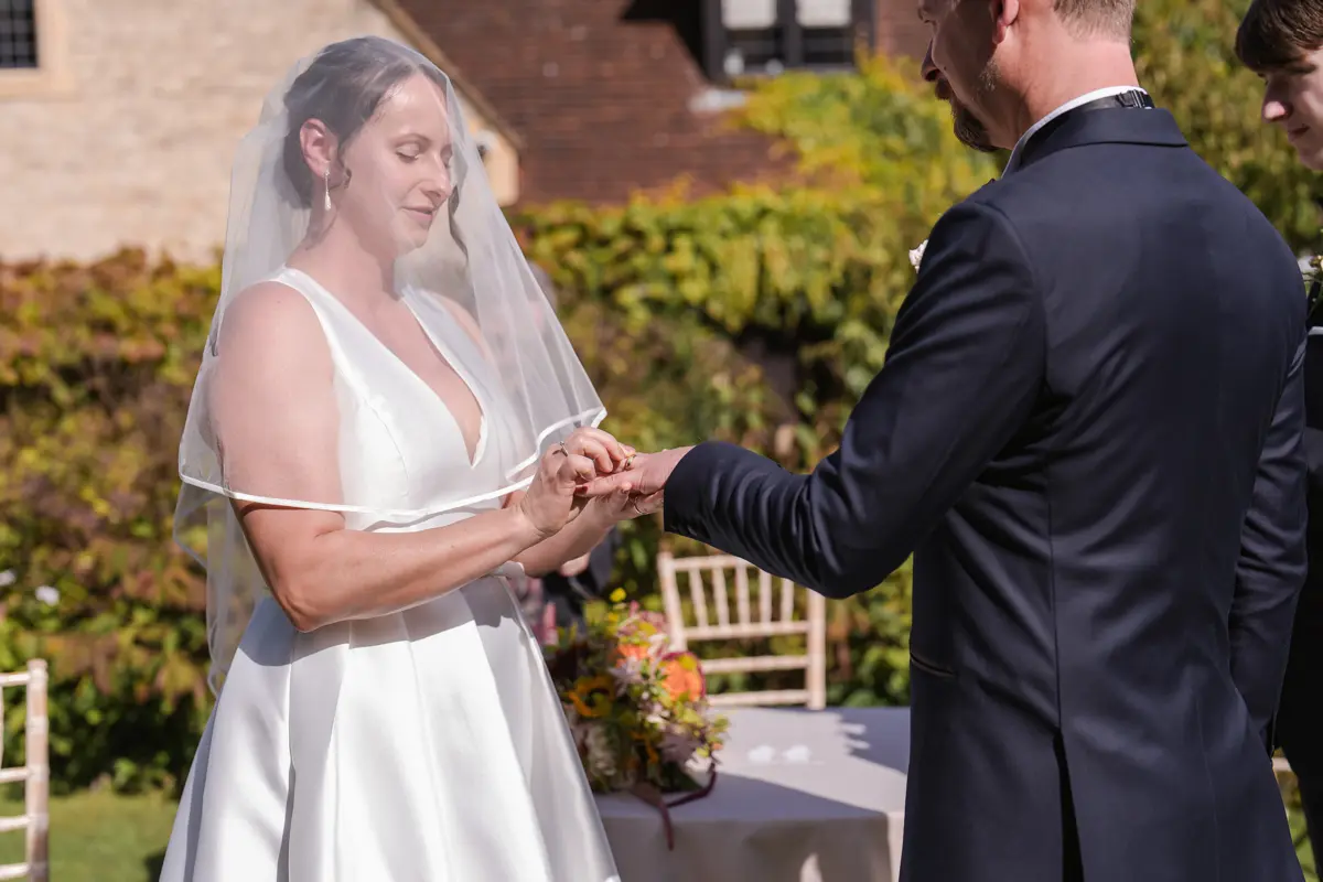 Bride and groom exchange rings at their Le Manoir wedding in September. la belle epoque outdoor wedding ceremony.