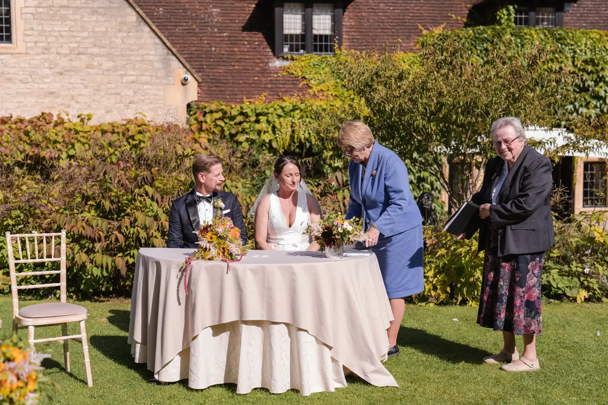Bride and groom doing paperwork at their Le Manoir wedding in September. la belle epoque outdoor wedding ceremony.