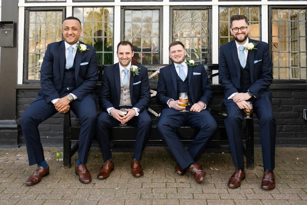 Bull Hotel wedding photography. Groomsmen with beer in front of the hotel.