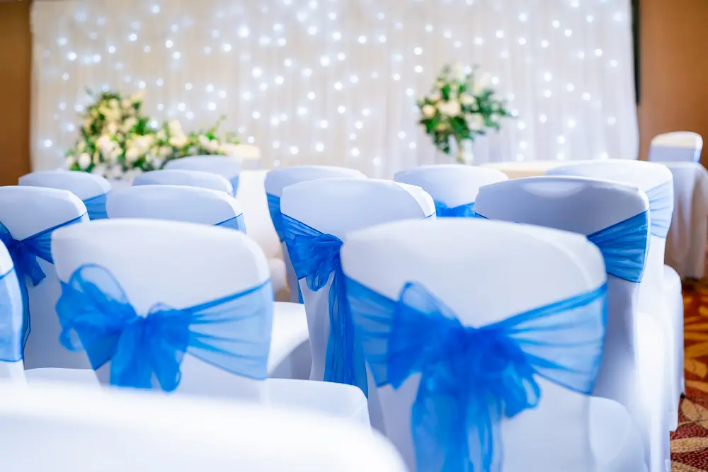 Bull Hotel wedding photography. Blue ribbons on seats and white sparkling wall.