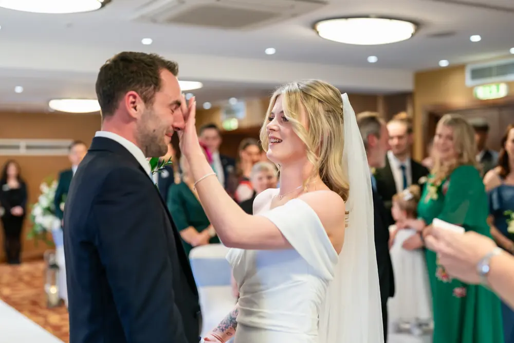 Bull Hotel wedding photography. Bride wipes a tear from groom's eye.