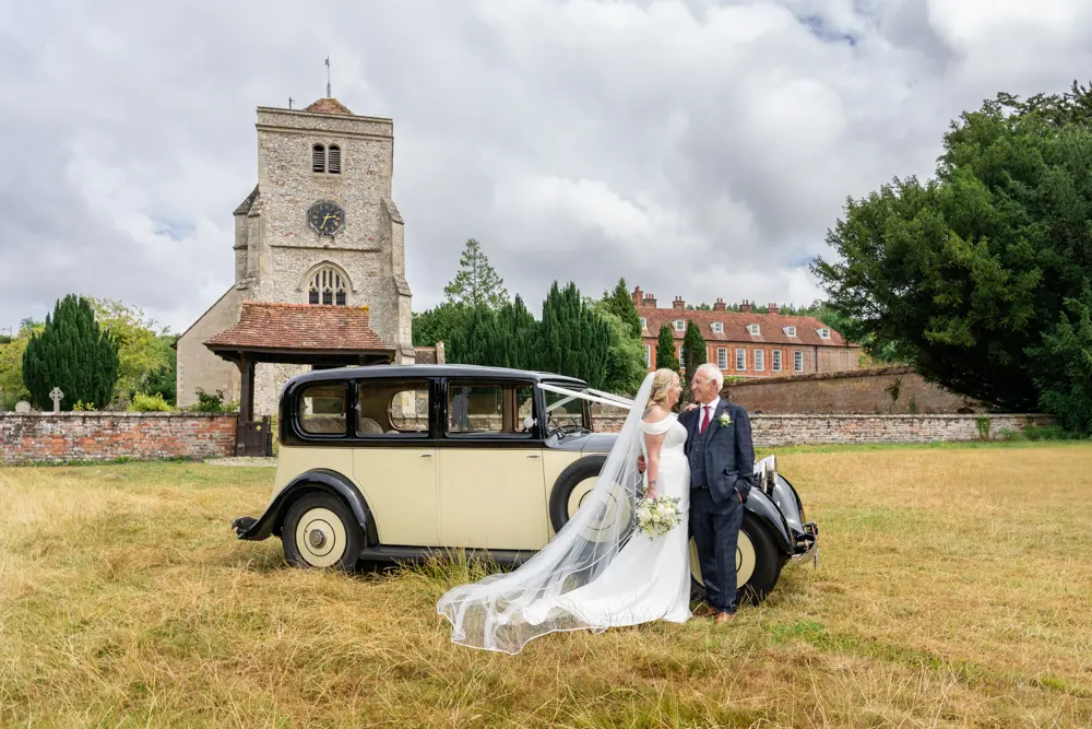 Bride and groom next to vintage rolls royce after wedding ceremony at St Boltoph church. Bradenham wedding photographer Buckinghamshire.