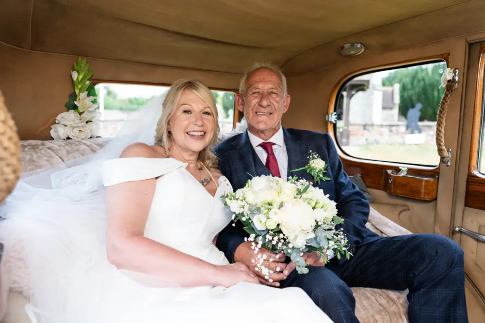 St Boltoph Bradenham wedding photography. Bride and groom in car leaving church after wedding ceremony.