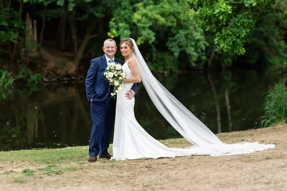 Stoke-Place-Wedding-Photographer. Bride and groom next to lake.
