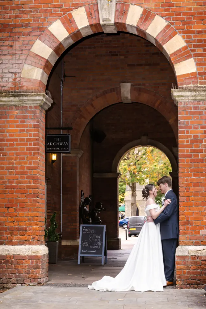 Bride and groom under arches after their Judges Lodgings Aylesbury wedding.