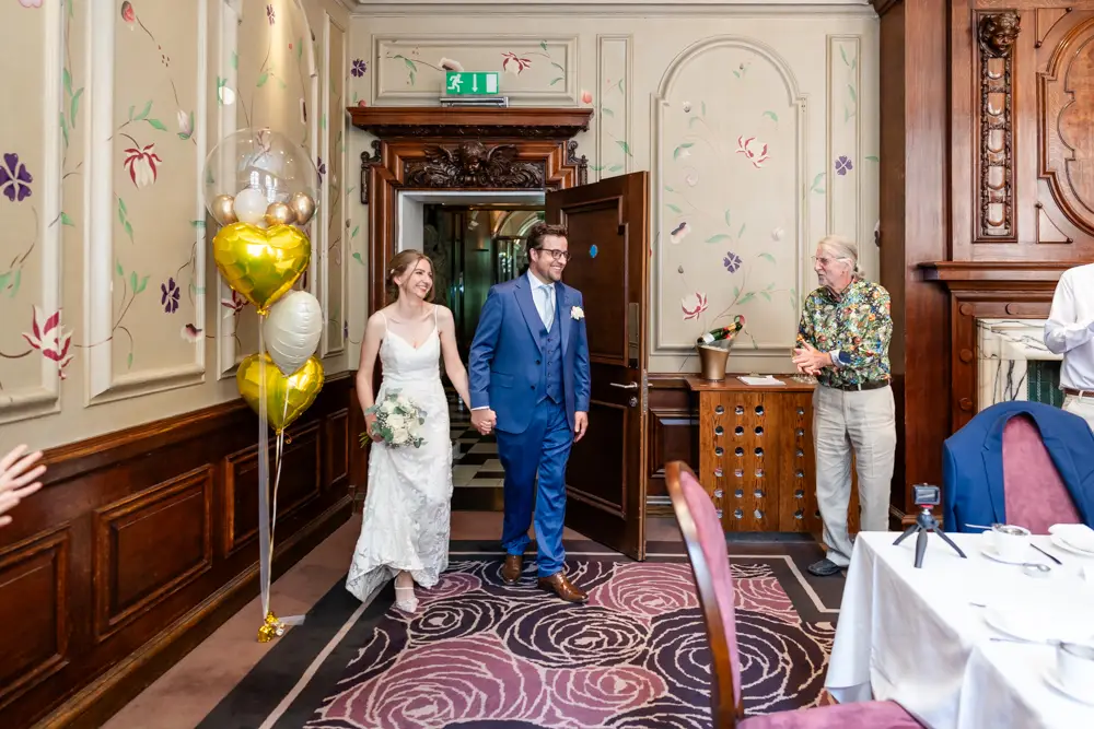 bride and groom enter wedding breakfast. Roseate wedding photographer in Reading.