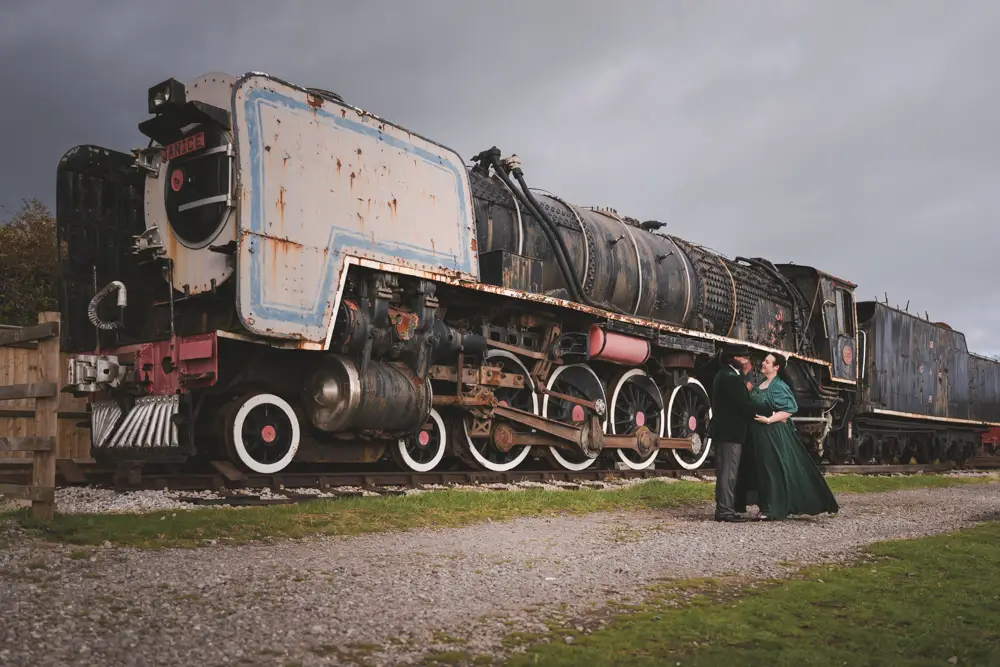 Buckinghamshire Railway Centre Wedding Photographer. Bride and groom at sunset next to south african locomotive.
