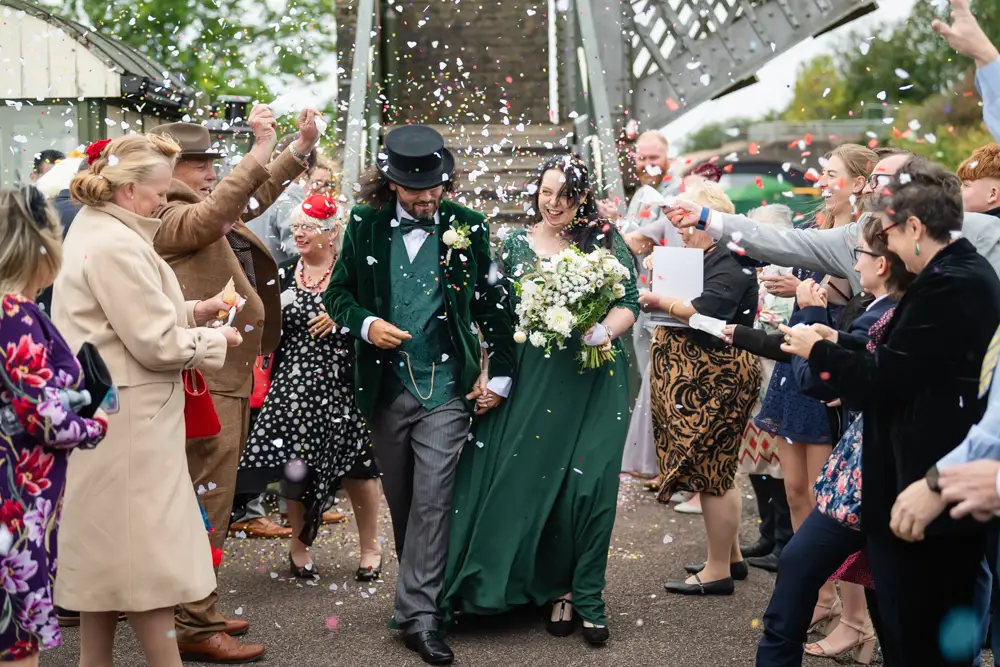 Buckinghamshire Railway Centre Wedding Photographer. Bride and groom confetti tunnel on Platform 2.