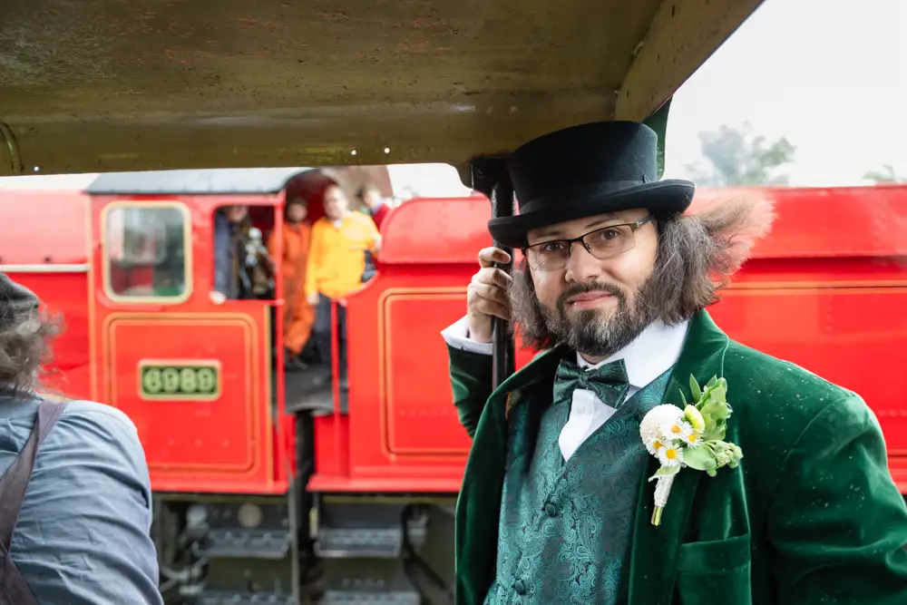 Buckinghamshire Railway Centre Wedding Photographer. Groom riding in the cab of steam engine.
