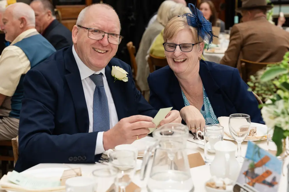 Buckinghamshire Railway Centre Wedding Photographer. Guests laughing in main hall.
