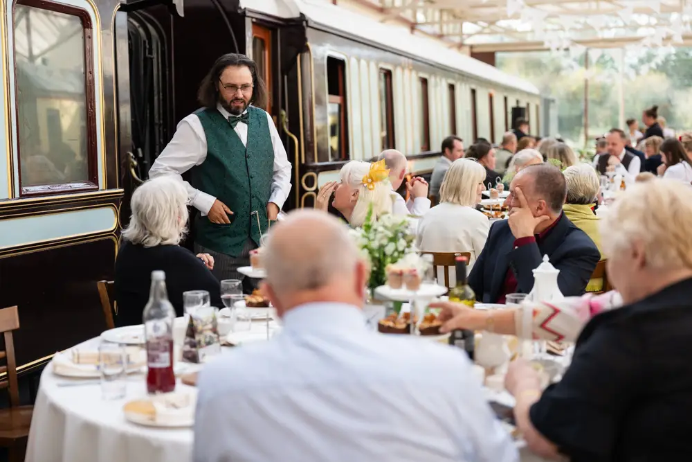 Buckinghamshire Railway Centre Wedding Photographer. groom chatting to guests in main hall.