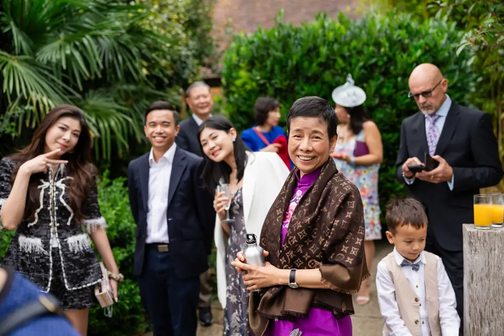 Notley Tythe Barn Wedding Photography. Wedding guests chatting outside barn.