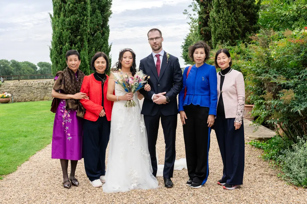 Notley Tythe Barn Wedding Photography. Group photo against car park backdrop