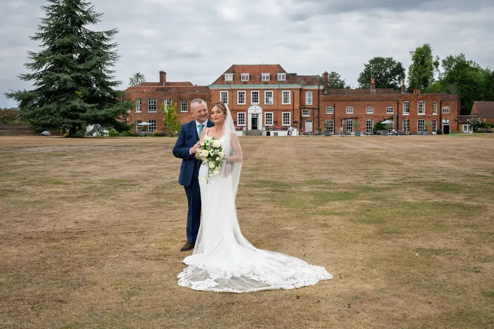 Stoke Place wedding photographer. Bride and groom with south elevation of Stoke Place in Buckinghamshire.