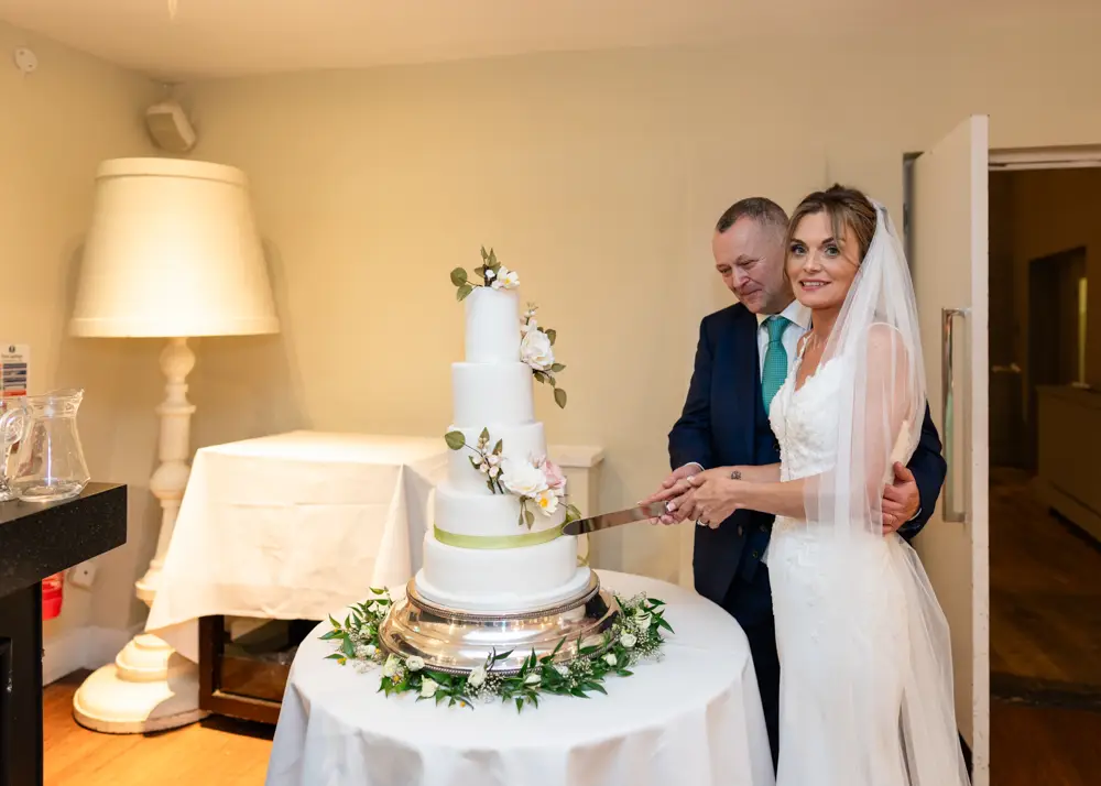 Stoke Place wedding photographer. bride and groom cutting cake