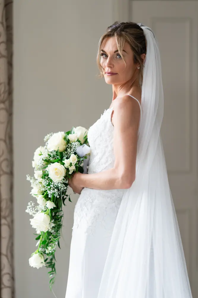 Stoke Place wedding photographer. Bride with bouquet in Alexandra suite before wedding.