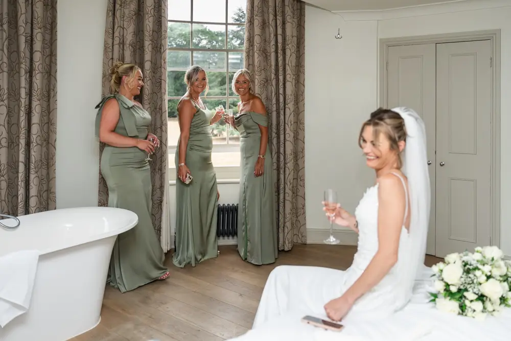 Stoke Place wedding photographer. Bride and bridesmaids laughing in Alexandra suite.
