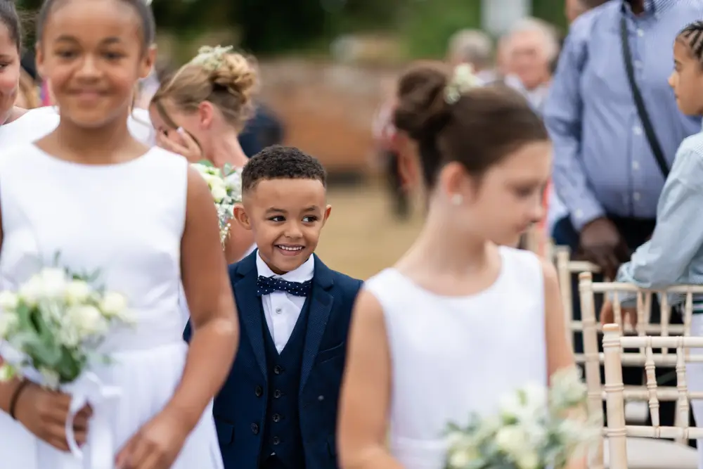 Stoke Place wedding photographer. Pageboy arriving for outdoor wedding ceremony