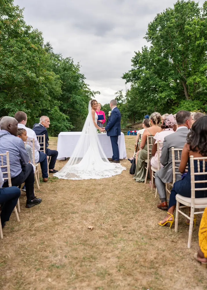 Stoke Place wedding photographer. Bride and groom during outdoor ceremony.