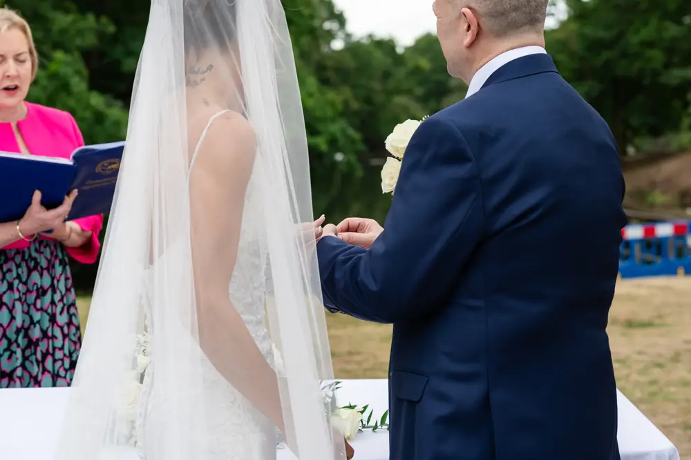 Stoke Place wedding photographer. Bride and groom during outdoor ring ceremony.