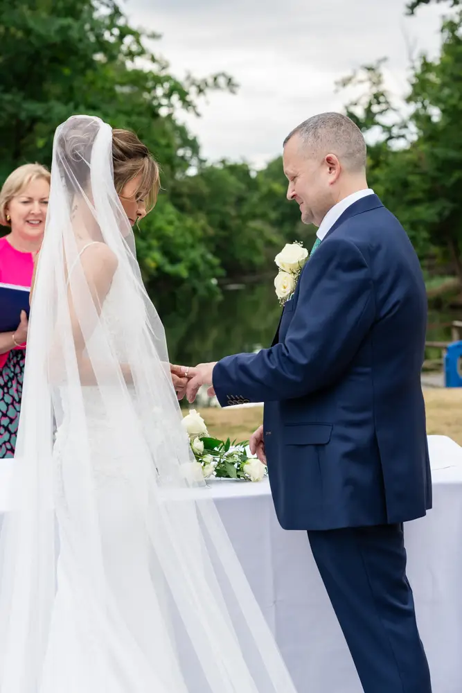 Stoke Place wedding photographer. Bride and groom during outdoor ring ceremony.