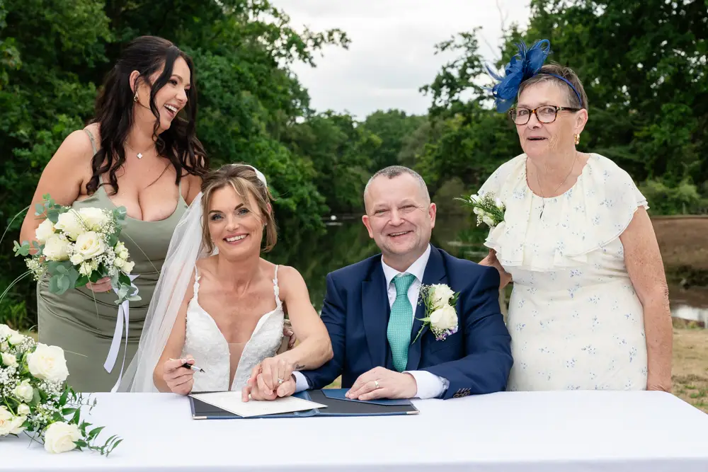 Stoke Place wedding photographer. Bride and groom with witnesses laughing.