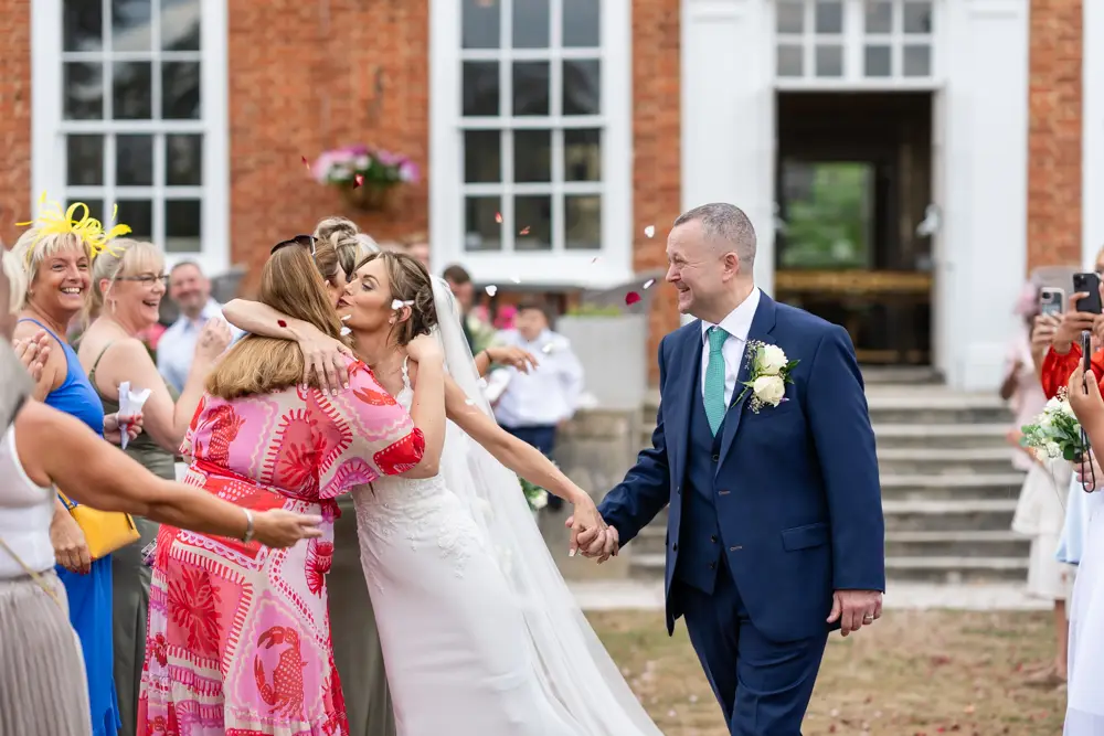 Stoke Place wedding photographer. Bride and groom in confetti tunnel.