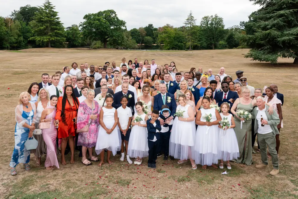 Stoke Place wedding photographer. Bride and groom with all guests.