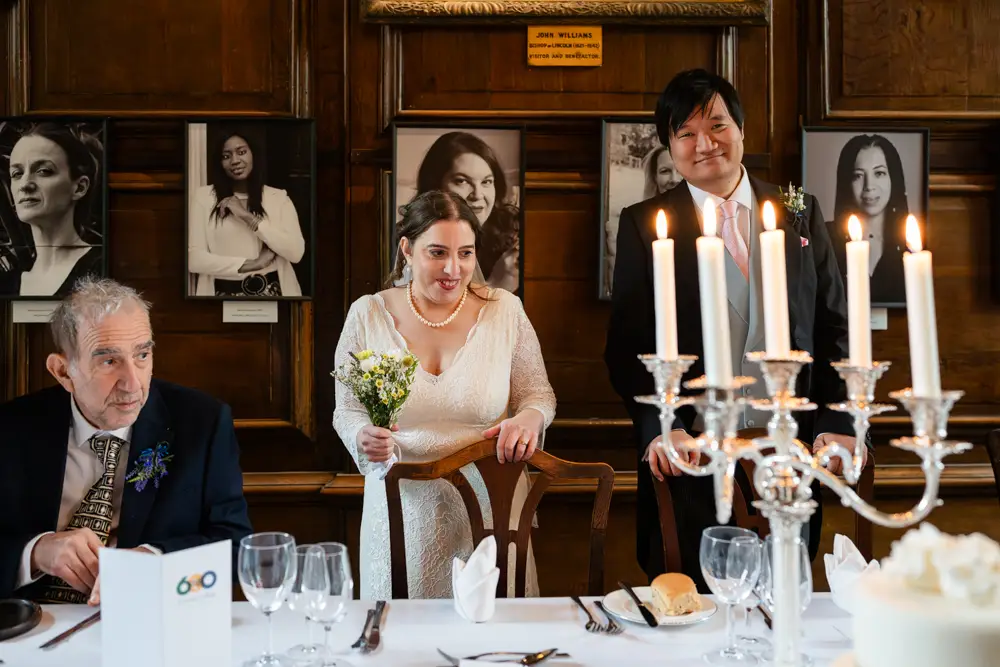 Lincoln College Oxford wedding photographer. Bride and groom about to be seated in the dining hall for the wedding breakfast.