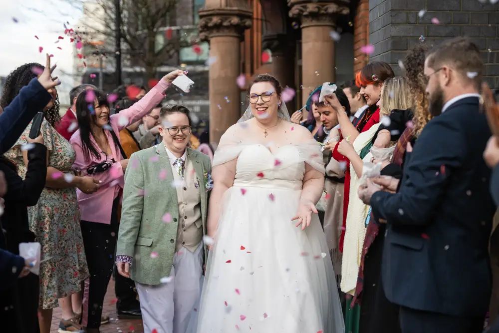 Newlyweds in confetti tunnel outside Reading Town Hall.
